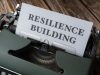 a typewriter with the word resilience building on it