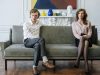 woman in white dress shirt and black pants sitting on gray couch