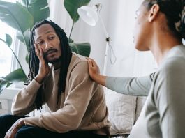 ethnic psychologist touching black depressed clients shoulder